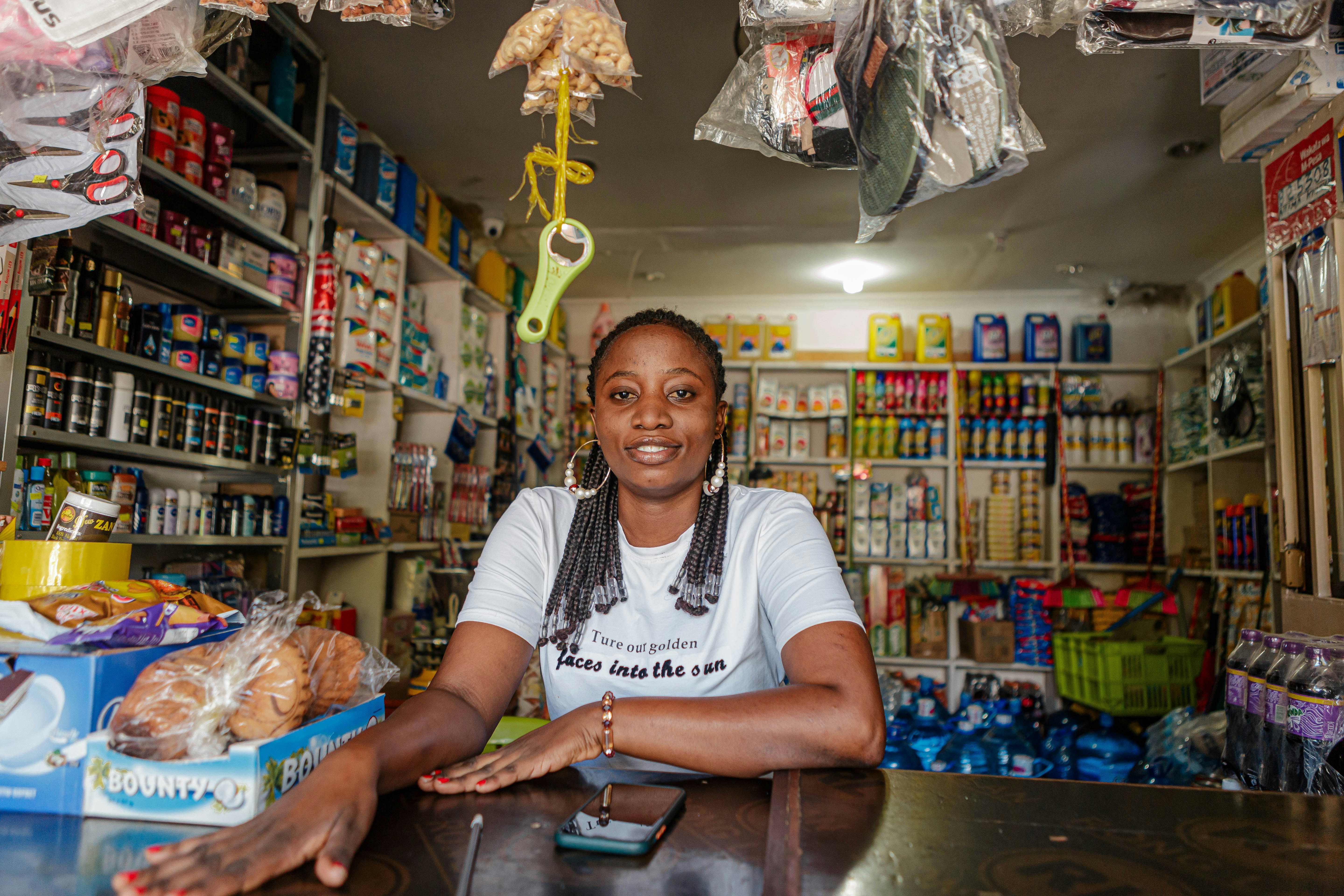 Small business owner smiling behind a shop counter, welcoming a returning customer