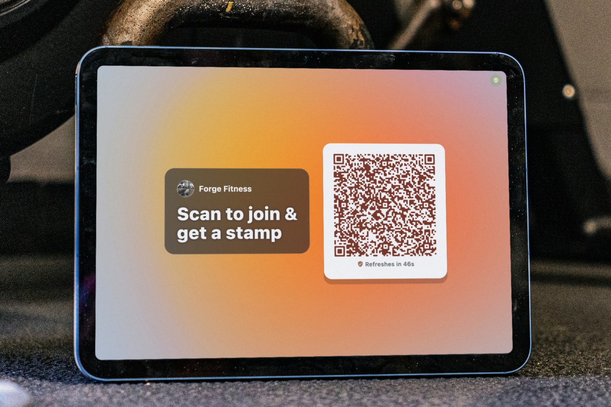 Illustration: an iPad leaning against a kettlebell on a gym floor shows the Forge Fitness self check-in screen, with the headline Scan to join and get a stamp next to a QR code that refreshes in 46 seconds