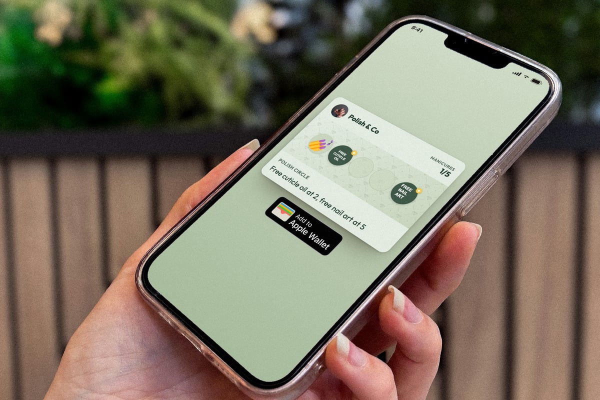 Illustration: a hand with manicured nails holds a phone showing the Polish & Co loyalty card at 1 of 5 manicures with the line "Free cuticle oil at 2, free nail art at 5" and an Add to Apple Wallet button